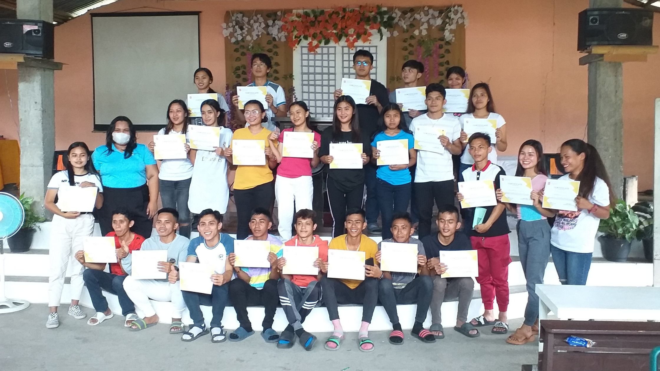 Students holding up their degree at the Community School Partnership in the Phillipines